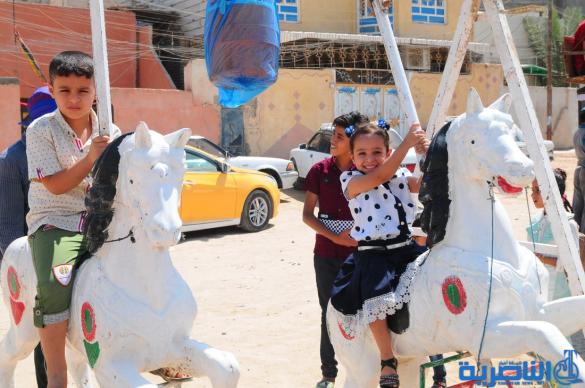 بالصور:اطفال الناصرية يقضون اول ايام عيد الفطر بالساحات والمتنزهات العامة
