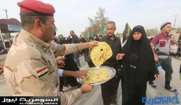  بالصور.. يدٌ تطعم وأخرى تحمي الزائرين الوافدين على كربلاء
