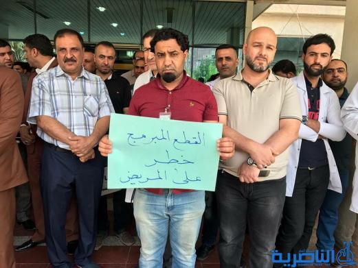 منتسبو مستشفى الحسين يحتجون على شموله بالقطع المبرمج ، والكهرباء تنفي
