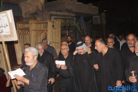 بالصور:موكب جمعية التضامن الاسلامي يحيي ليلة الحادي عشر من المحرم بمسيرة من الشموع