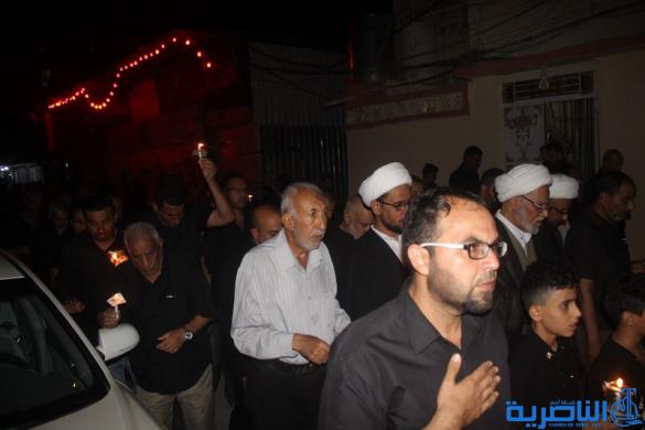 بالصور:موكب جمعية التضامن الاسلامي يحيي ليلة الحادي عشر من المحرم بمسيرة من الشموع