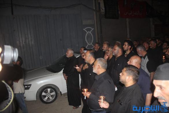 بالصور:موكب جمعية التضامن الاسلامي يحيي ليلة الحادي عشر من المحرم بمسيرة من الشموع