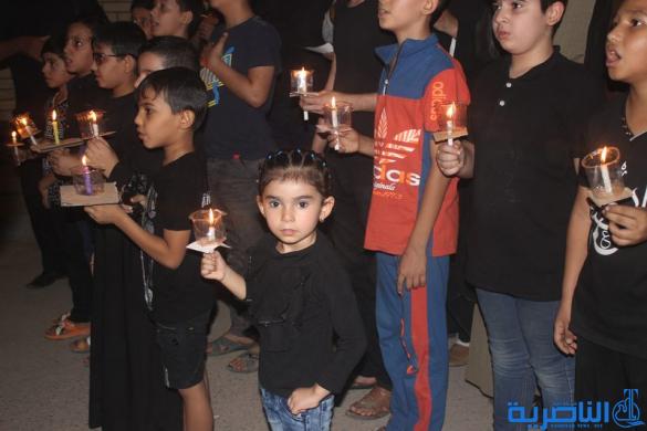 بالصور:موكب جمعية التضامن الاسلامي يحيي ليلة الحادي عشر من المحرم بمسيرة من الشموع