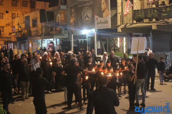 بالصور:موكب جمعية التضامن الاسلامي يحيي ليلة الحادي عشر من المحرم بمسيرة من الشموع