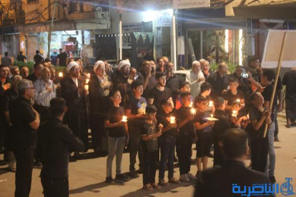 بالصور:موكب جمعية التضامن الاسلامي يحيي ليلة الحادي عشر من المحرم بمسيرة من الشموع