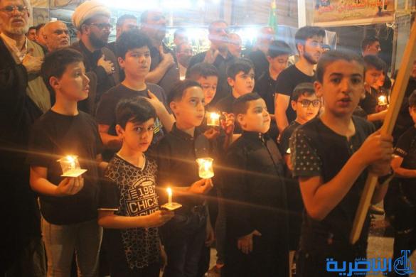 بالصور:موكب جمعية التضامن الاسلامي يحيي ليلة الحادي عشر من المحرم بمسيرة من الشموع