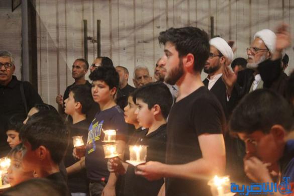 بالصور:موكب جمعية التضامن الاسلامي يحيي ليلة الحادي عشر من المحرم بمسيرة من الشموع