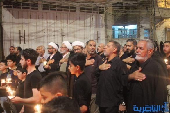 بالصور:موكب جمعية التضامن الاسلامي يحيي ليلة الحادي عشر من المحرم بمسيرة من الشموع
