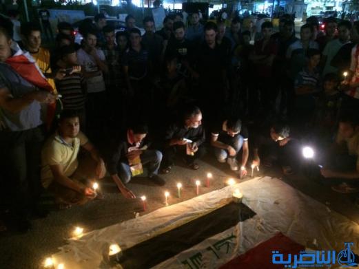 بالصور: الناصرية توقد الشموع حزنا على شهداء الكرادة