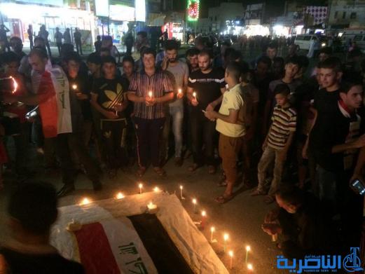 بالصور: الناصرية توقد الشموع حزنا على شهداء الكرادة